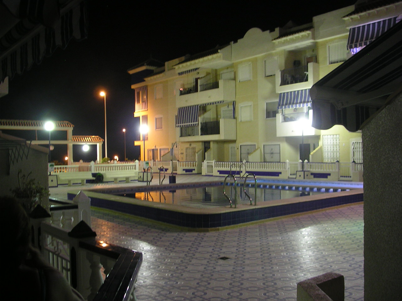 www.costaalquiler.com - vista nocturna de la piscina y patio del apartamento turistico de Torrevieja en alquiler